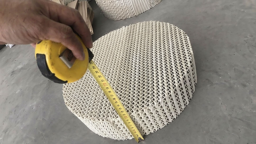 Macro close-up of ceramic structured packing corrugated sheet surface showing 45-degree channel angle and glaze texture